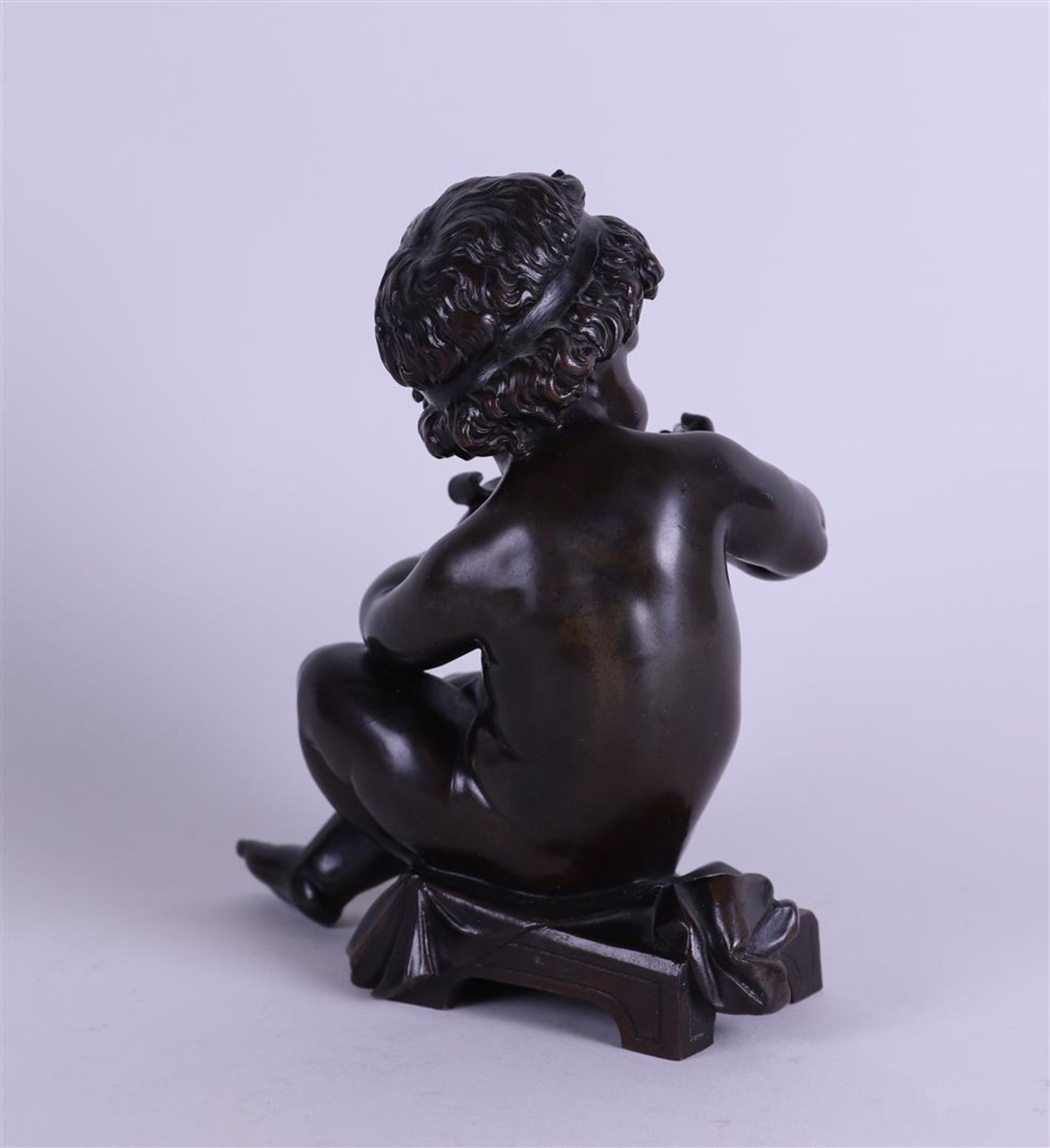 A brown patinated bronze of a writing putto. 19th century. - Image 3 of 5