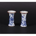 Two porcelain beaker vases with flared necks, decorated with a bird of paradise on a rock decor.