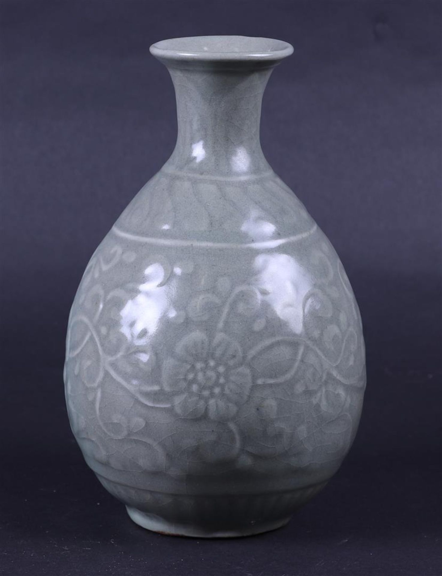 A Celadon vase with floral relief. China, Ming.