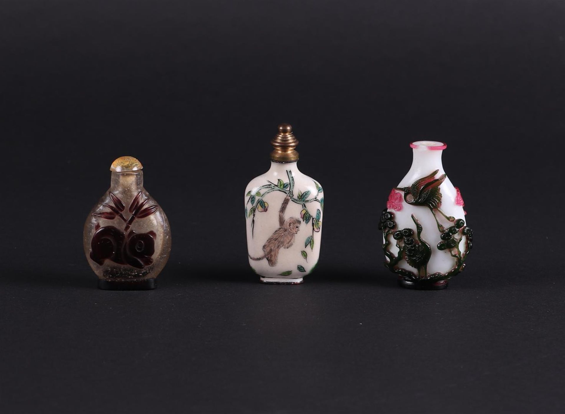 A lot of three snuff bottles including some in enamel. China, 20th century.
