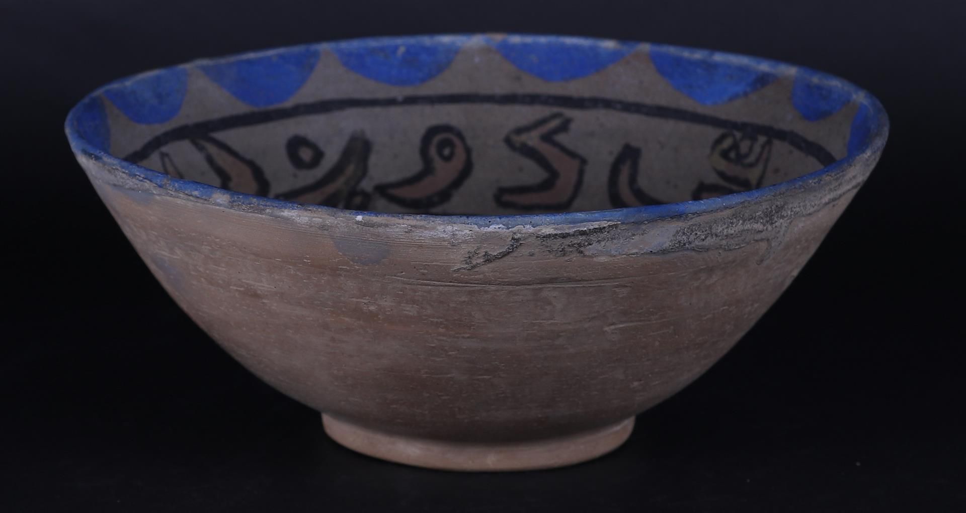 An earthenware Nishapur bowl with floral decor and decorated in the center with a fable figure.  - Bild 2 aus 3