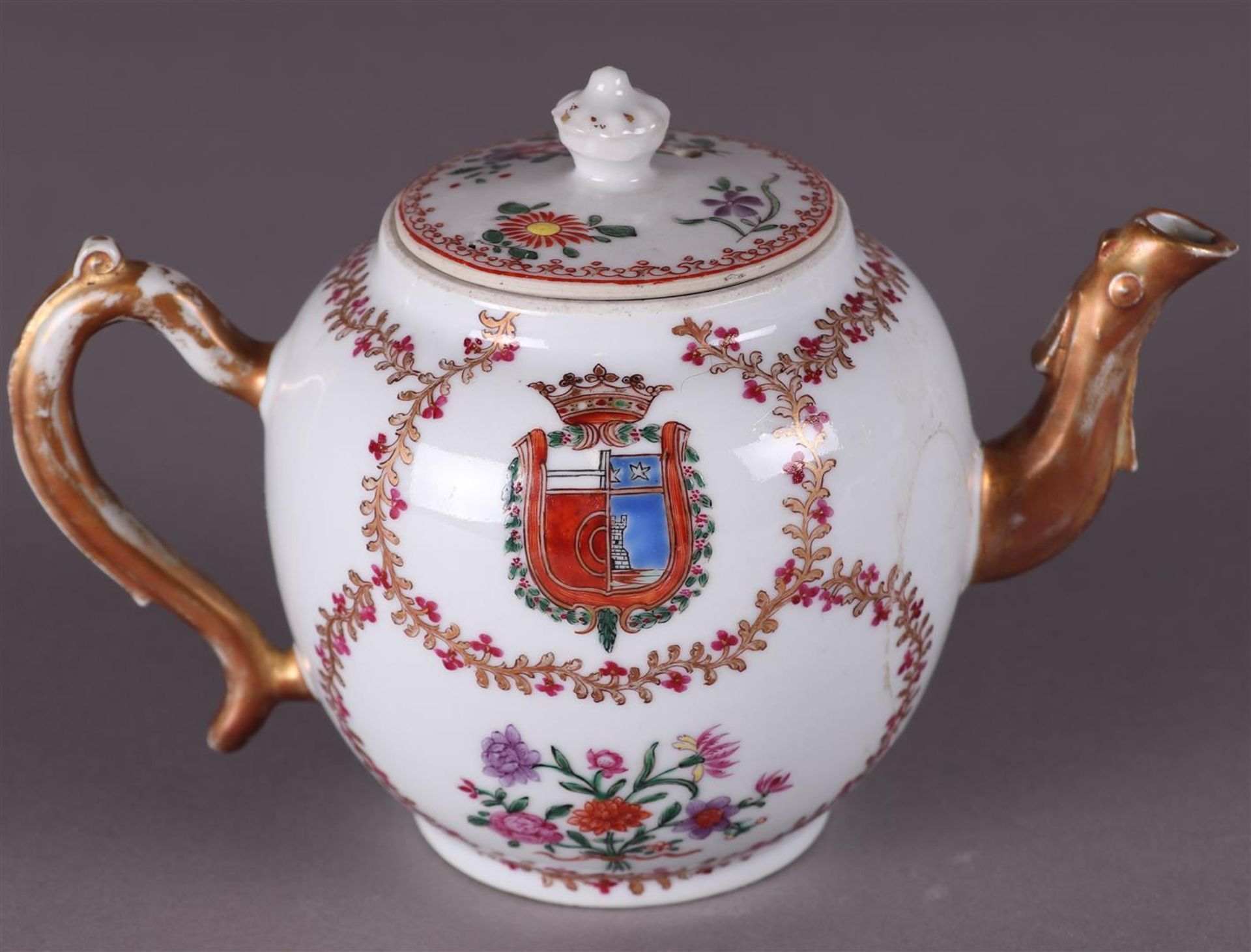 An 18th century porcelain teapot with family coat of arms.