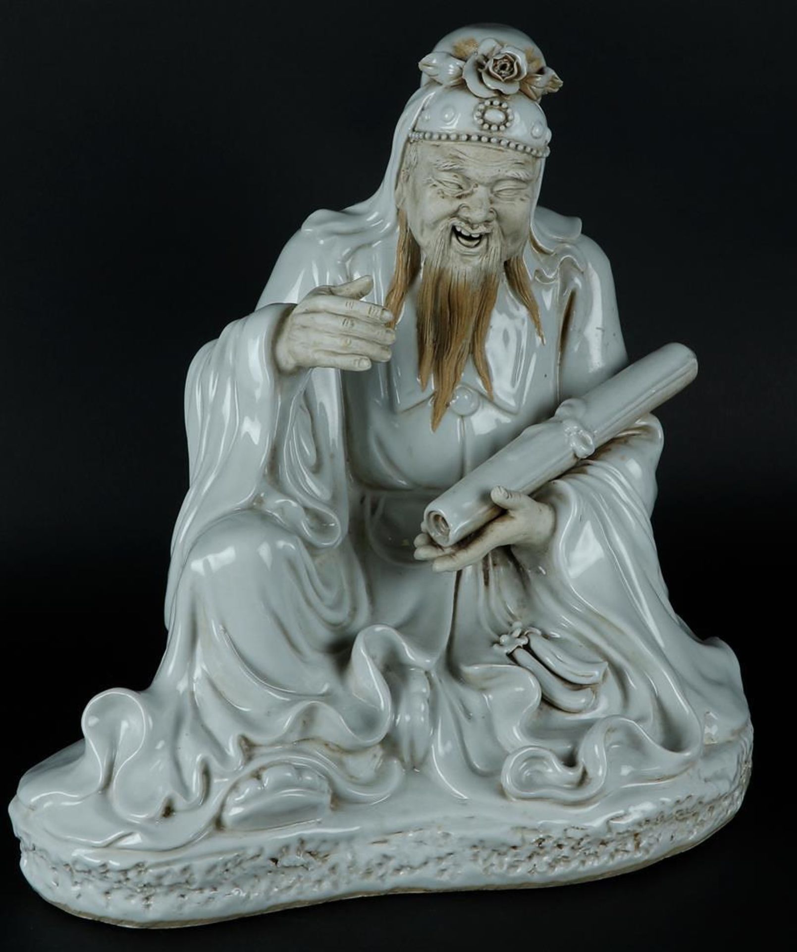 A porcelain Blanc de Chine sage with scroll drawing in hand, hands and face are unglazed. China