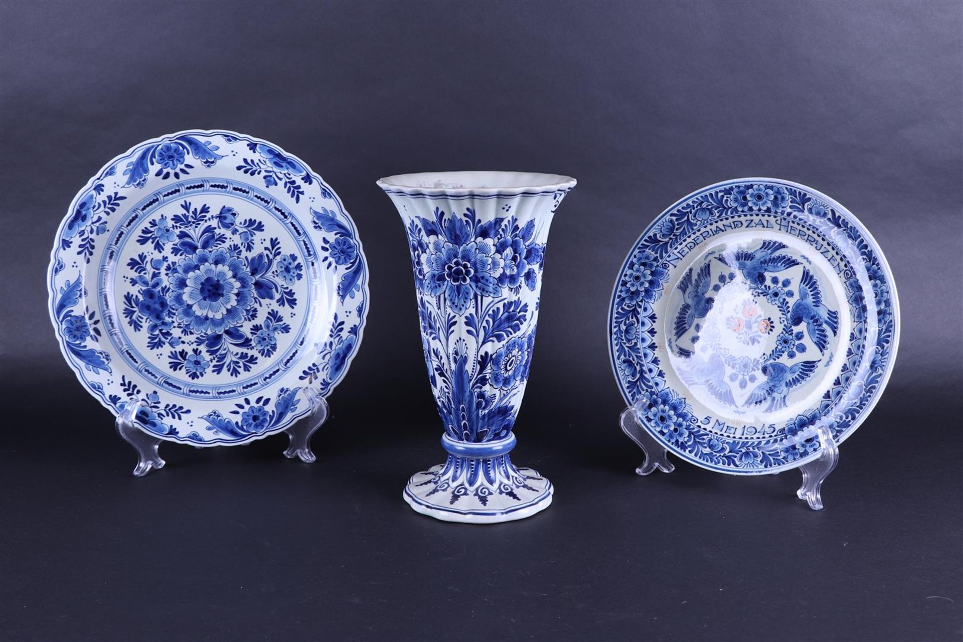 A Delft blue lot consisting of a trumpet vase, a saucer and a commemorative plate 