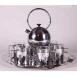 A design tea set consisting of a WMF teapot with tea light holder and Alessi tea mugs.