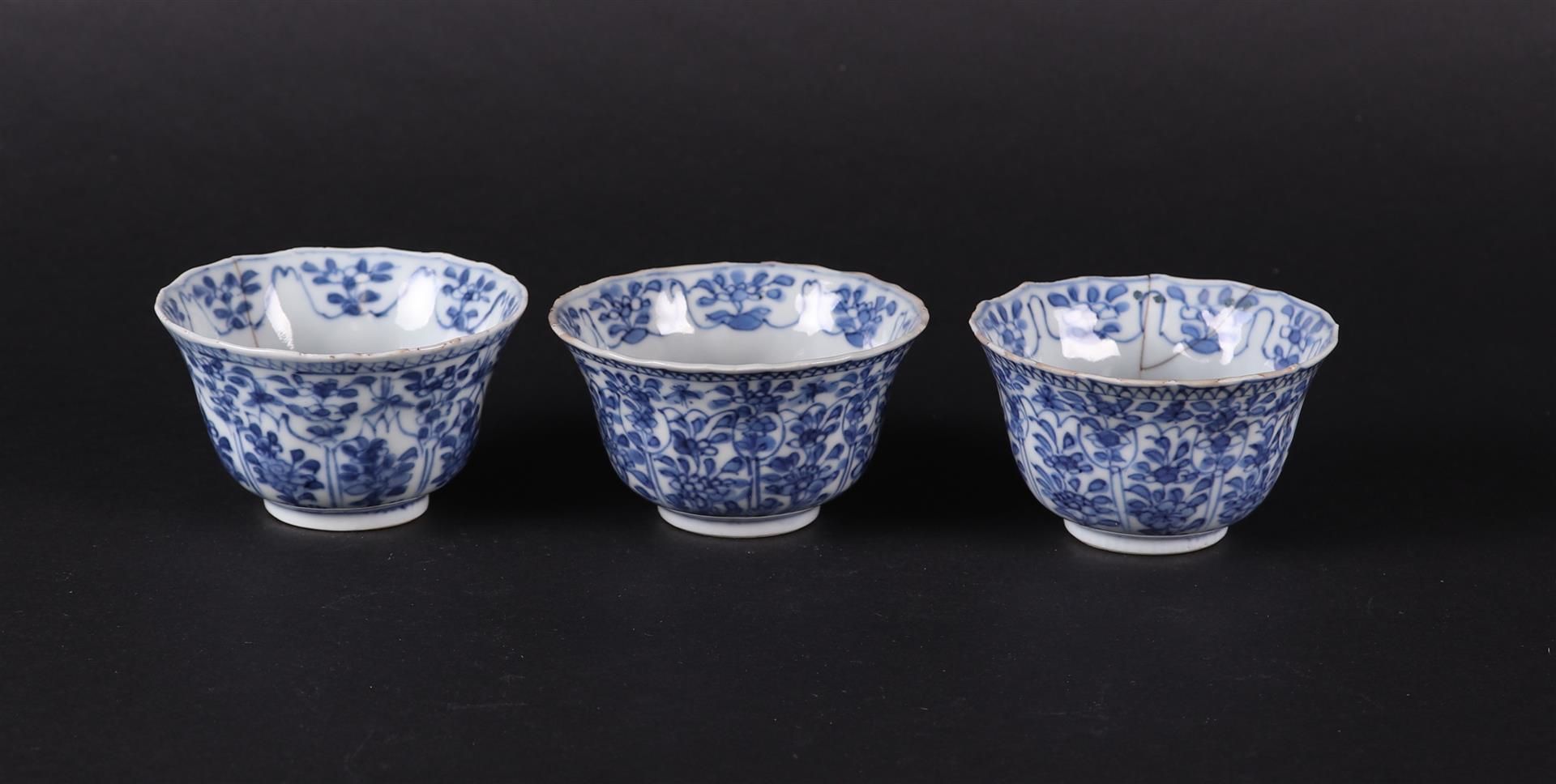 Three porcelain bowls with floral decoration on the outside,  