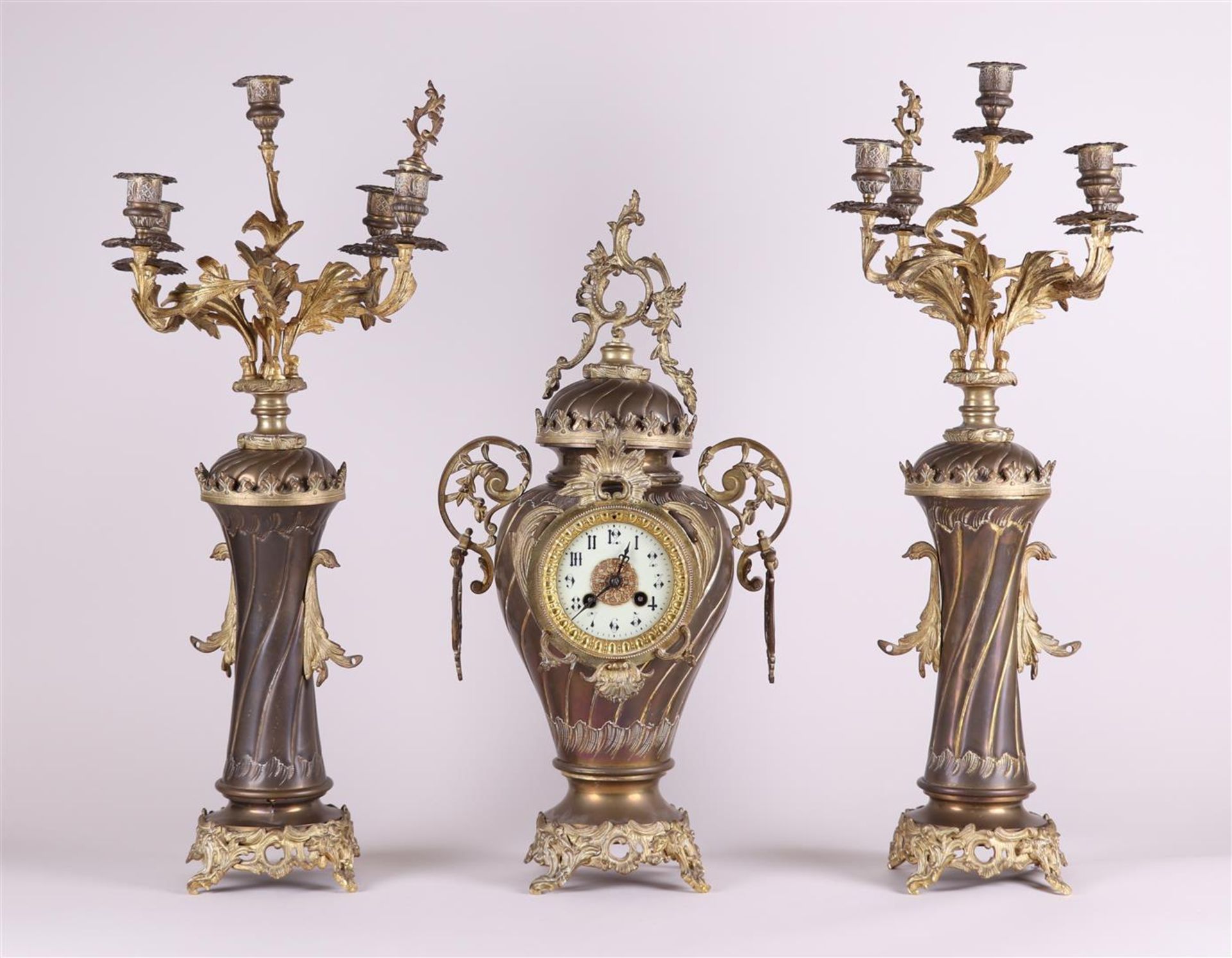 A French Garniture de Chéminé or clock set, consisting of a mantel clock and two candlesticks.