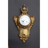 An ormolu plated cartel clock decorated with vase work and garlands, France late 18th century.