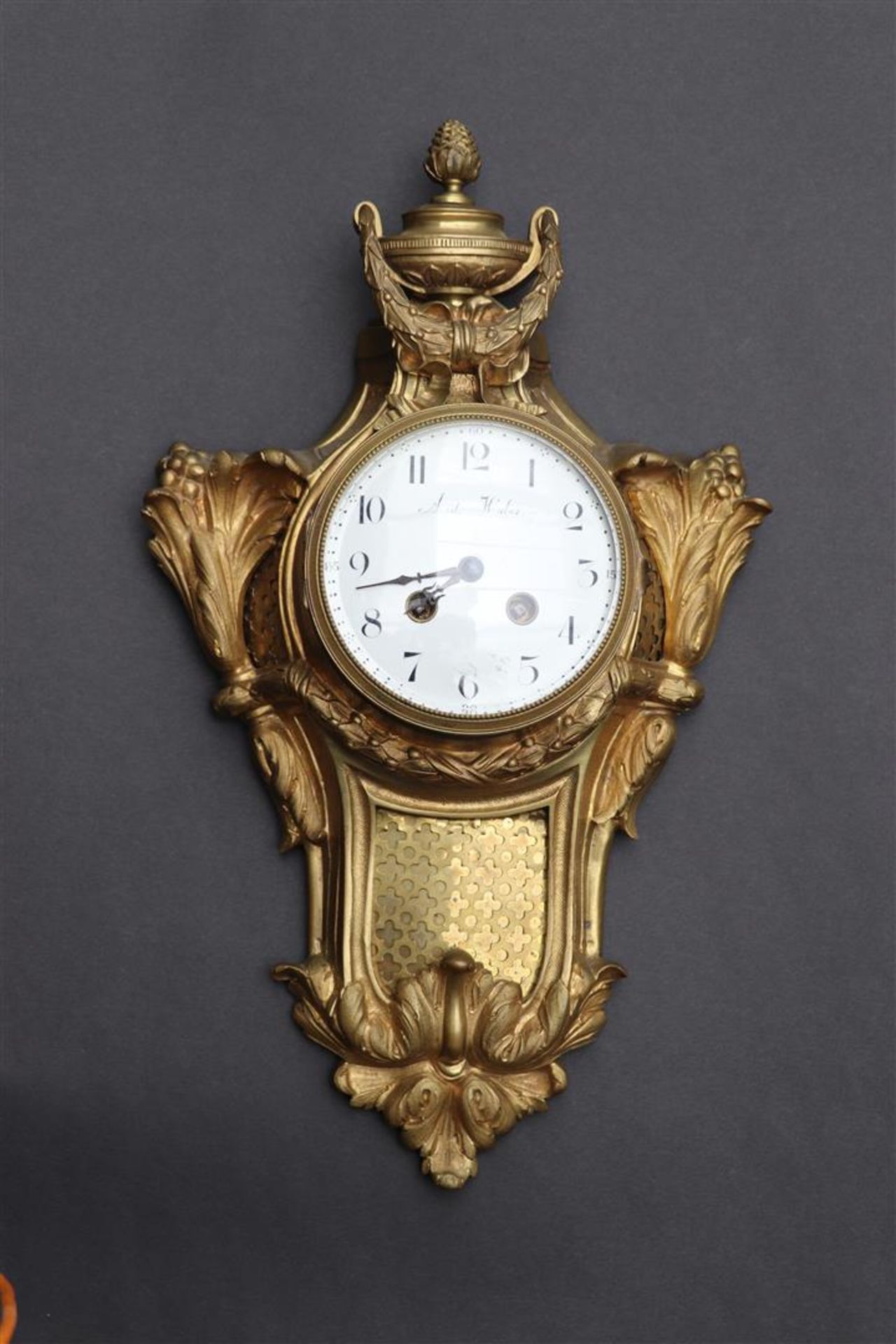 An ormolu plated cartel clock decorated with vase work and garlands, France late 18th century.