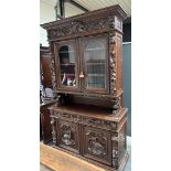 A French, antique hunting cupboard, the revolt carried by abstracted lions, with glass doors