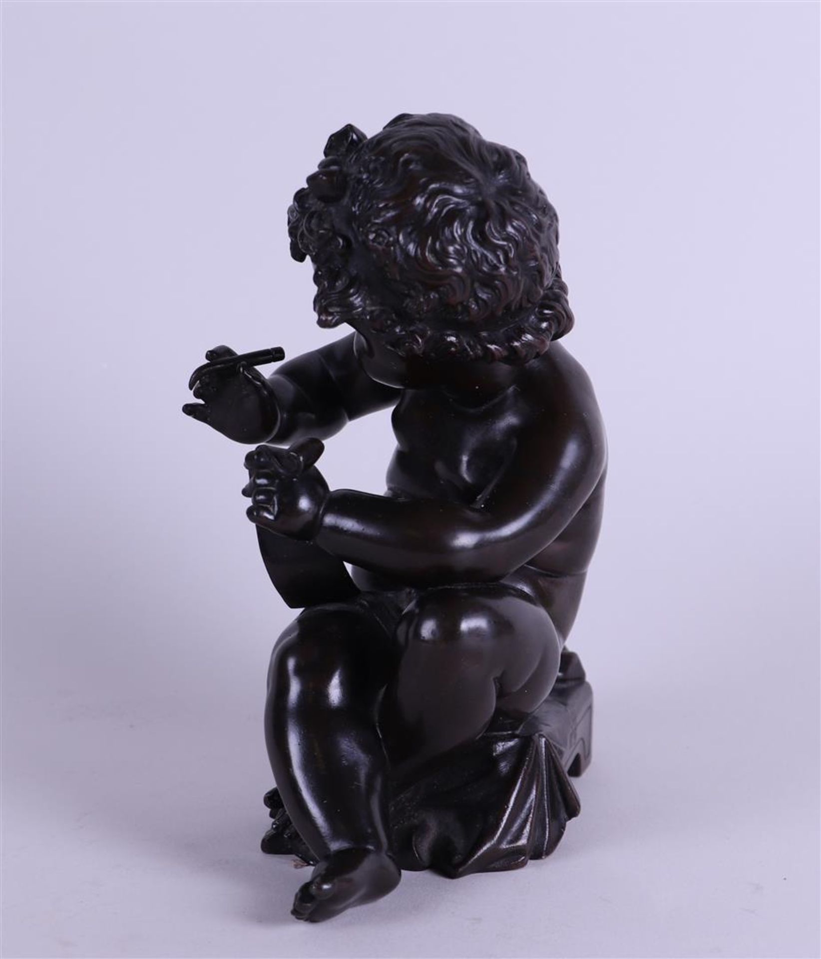 A brown patinated bronze of a writing putto. 19th century. - Image 2 of 5