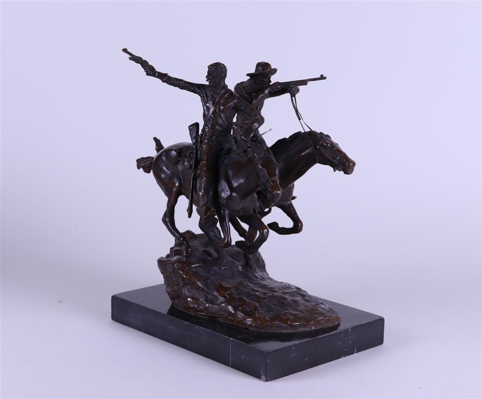 D'après Frédéric Remington, A bronze patinated sculpture of  cowboys on horseback, on a marble base