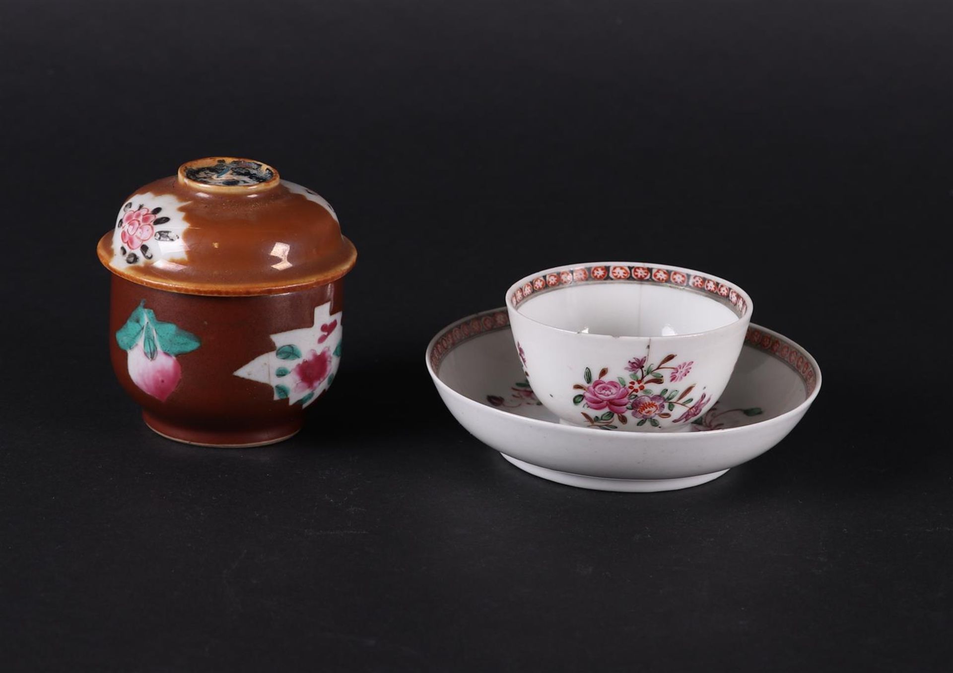 A porcelain Famille Rose cup and saucer with floral decor and sugar bowl with capuchin exterior