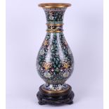 A cloisonne vase on a wooden base with floral decor. China, 20th century.
