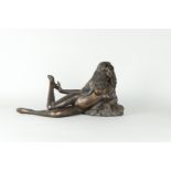 A bronze of a reclining lady with long hair.