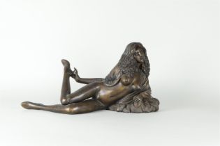 A bronze of a reclining lady with long hair.
