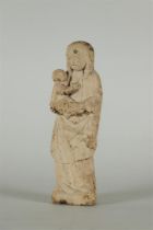 A primitive statue of Mary with Christ child, carved in sandstone.