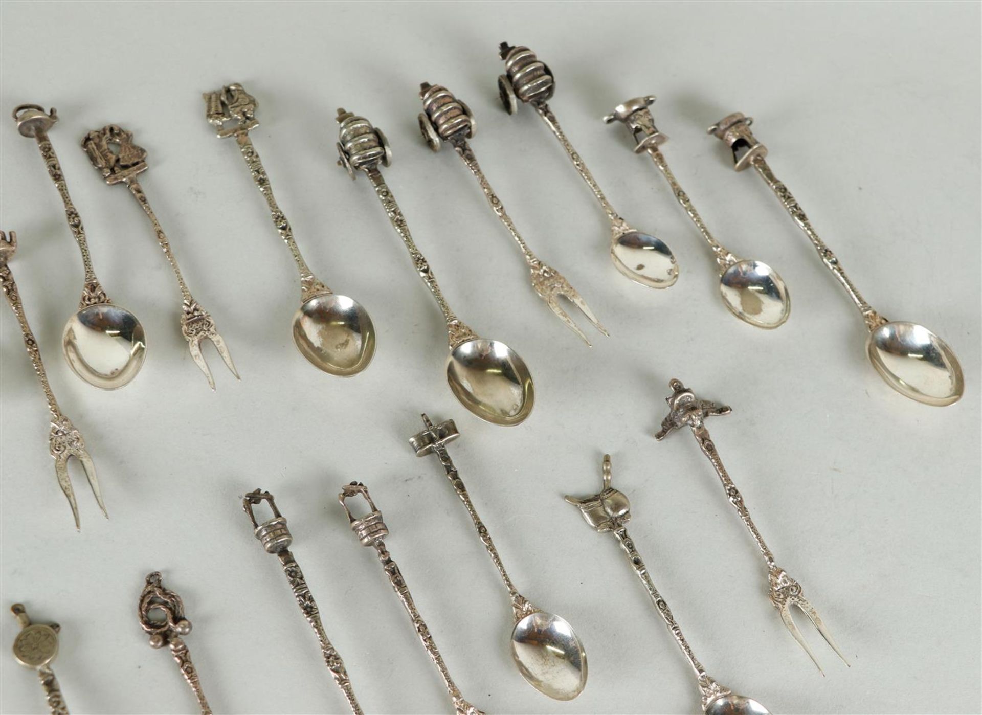 A large lot of (20) silver forks and spoons with wells, covered wagons, teapots etc.
