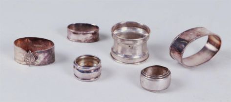 Four napkin rings, and two drop catchers in silver