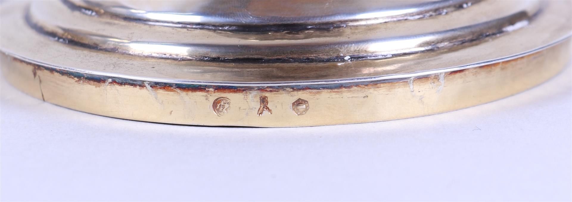 A silver lidded coupe on a round base with a constricted base surrounded by palm leaves, the lid wit - Image 2 of 3