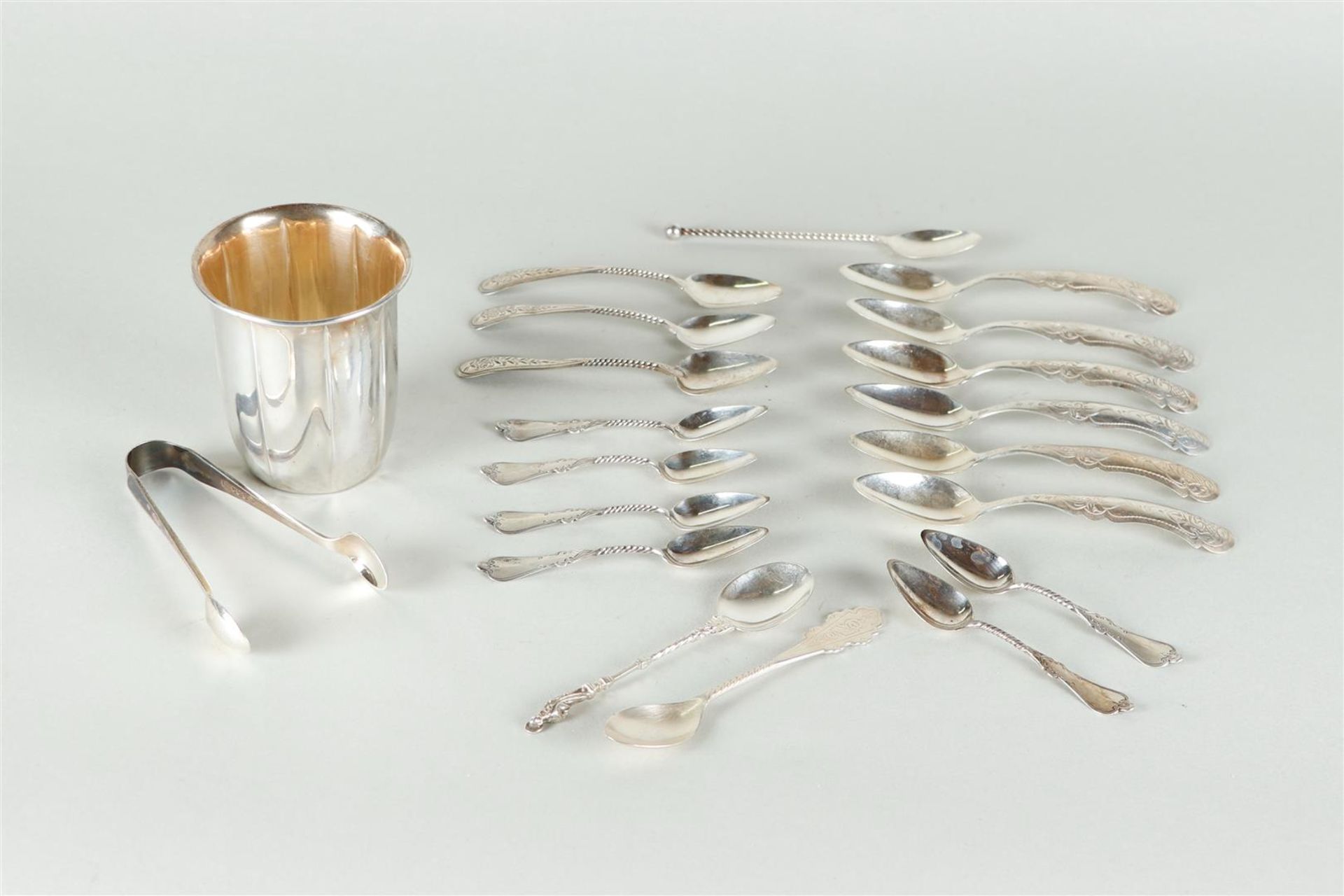 A silver spoon vase, assorted silver spoons and a lump tongs