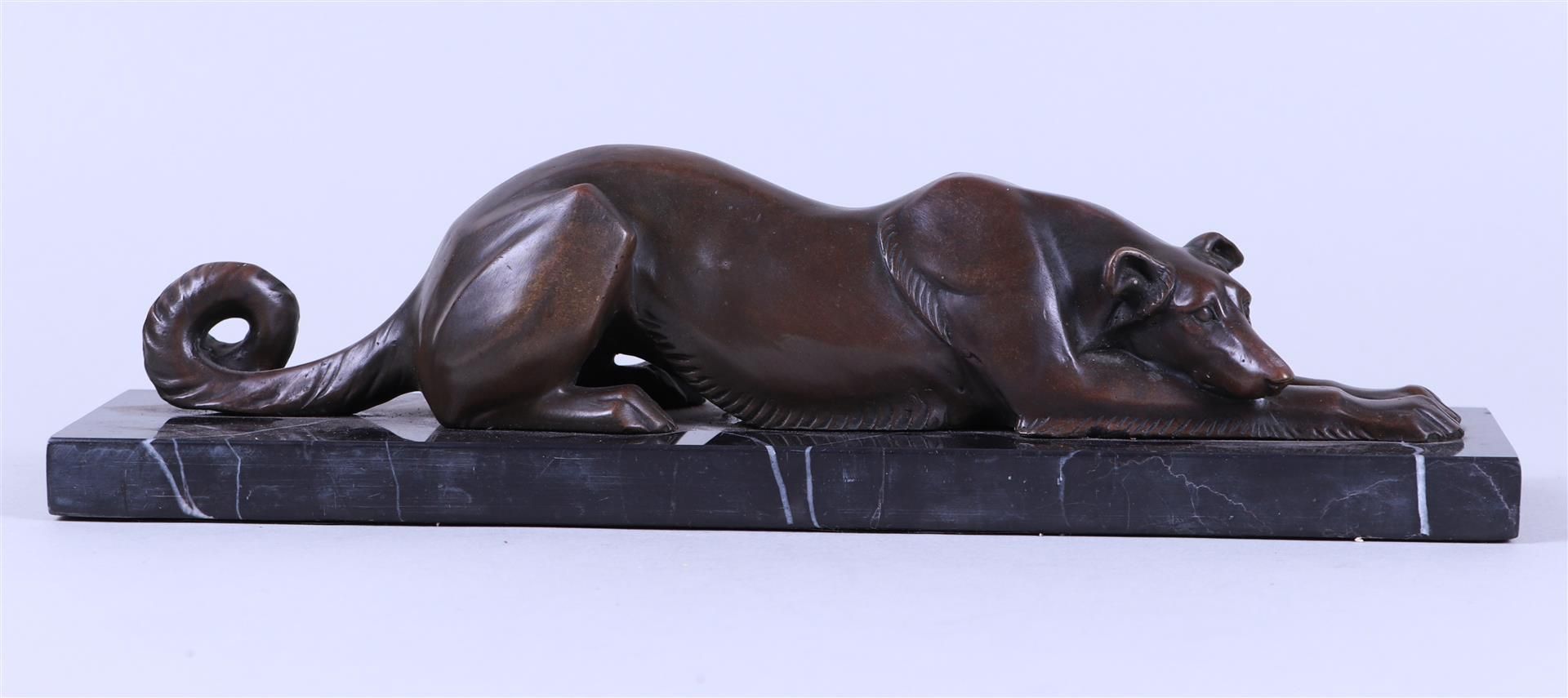 An Art Deco-style sculpture of a greyhound dog on a marble base.
