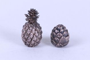 A lot consisting of (2) novelty pill boxes in the shape of an artichoke and a pineapple. 835/1000.