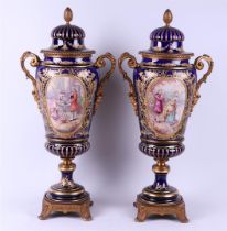 Two porcelain Sèvres style bronze lidded vases, hand-painted with scenes of classical figures on the