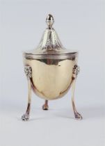 A silver lidded cup on three legs with lion masquerades, standing on claw feet, the lid with acorn-s