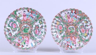 Two porcelain Canton plates with flowerbed decor depicting figures at a pavilion and floral decorati