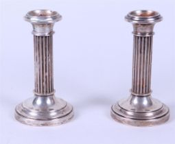 A pair of columnar fluted candlesticks, marked with a sword. 