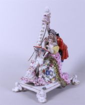 A porcelain figure of a harping lady and gentleman, marked on the bottom