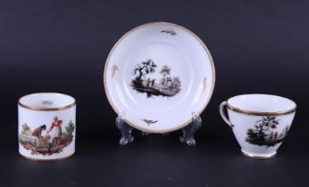 A porcelain cup and saucer with rich, grisaille, landscape decoration