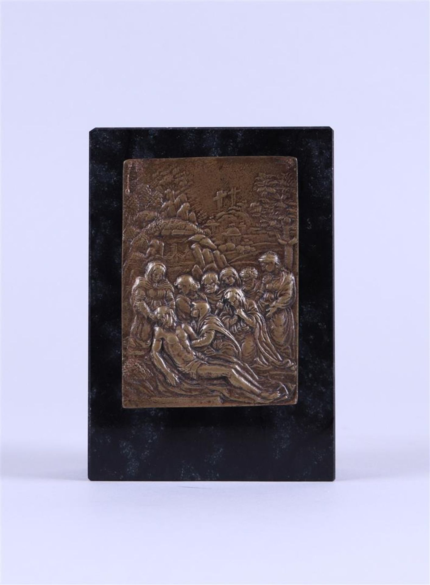 A bronze relief depicting the entombment of Christ mounted on a honed marble base
