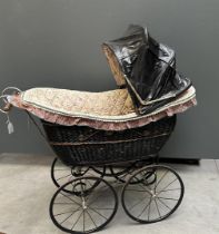 An antique pram with modern upholstery. Approx. 1900.