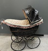 An antique pram with modern upholstery. Approx. 1900.
