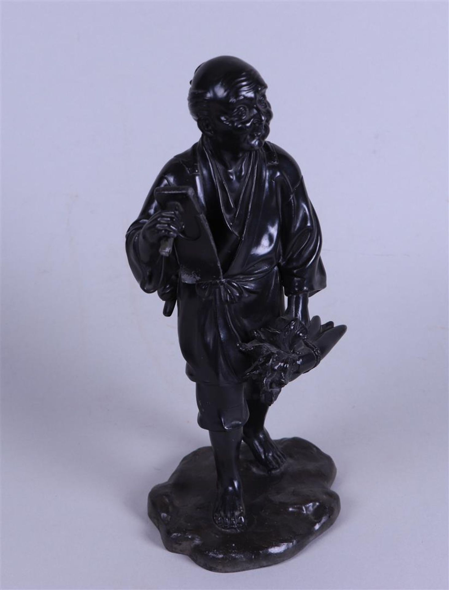 A pewter Okimono statue of a farmer. Japan, 20th century.
