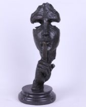 A bronze sculpture of a man calling for silence.