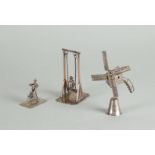 A lot comprising (3) silver miniatures, including a windmill, a cyclist, and a rocker