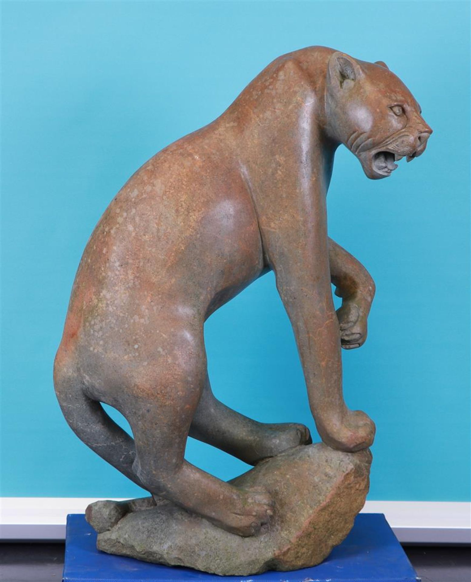 A hard stone sculpture of a puma on a rock. 20th century.