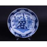 A Delft earthenware dish with floral decor in the middle, after a Chinese example