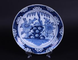 A Delft earthenware dish with floral decor in the middle, after a Chinese example