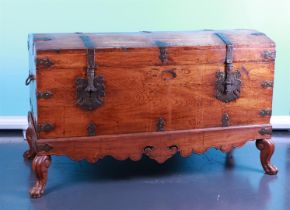 A blanket chest with wrought iron fittings mounted on claw feet. Approx. 1900.