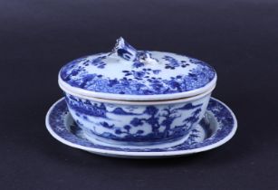 A porcelain lidded terrine with saucer, decorated with various landscapes and lid knob in the shape