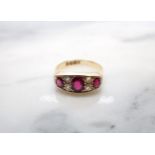 An Edwardian Ruby and Diamond Ring pavé-set three graduated oval-cut rubies with pairs of old-cut
