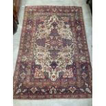 An antique Persian Rug with stylised floral motifs within trailing foliage on cream ground within