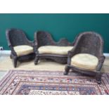 A Burmese matched carved three piece suite comprising two armchairs and a settee with pierced floral