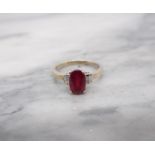 A Ruby and Diamond Ring claw-set oval-cut ruby between two pairs of channel-set baguette diamonds in