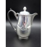 A George III silver baluster Hot Water Jug, engraved crest, the hinged cover with bud finial,