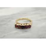 A Ruby five stone Ring claw-set round stones in various shades in 18ct gold, ring size O 1/2, approx